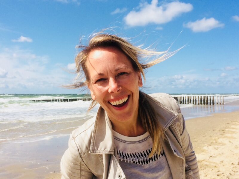 Portret van lachende Manon Erkens op het strand