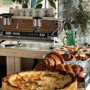 Een koffieshop met gebak en Magic Mantra Kickstart Workshop op een tafel genaamd Twin Fin Coffee Heiloo.