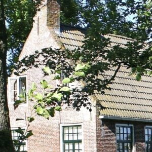 Een raadselachtig bakstenen huis, genesteld in de betoverende bossen van Fryslân, dat de uitstraling van Magic Mantra Weekend Fryslân uitstraalt | Magisch weekend vol mantra's.